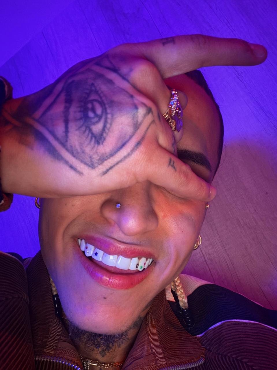 Dennis sonriendo bajo luz neón